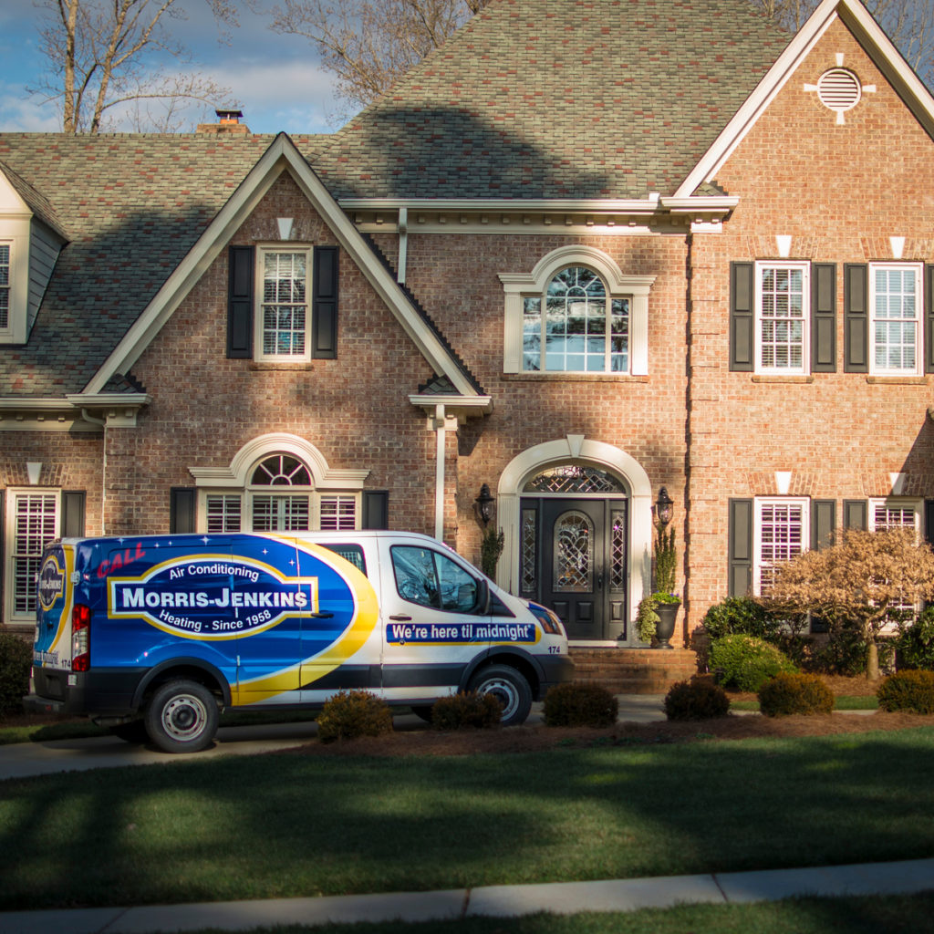 Morris-Jenkins service van parked outside a large brick home