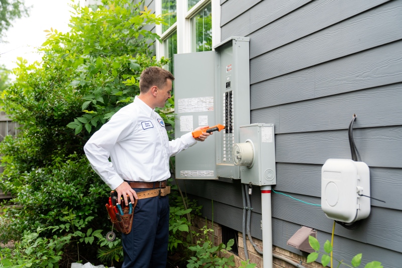 technician testing circuit breaker on outdoor electrical panel