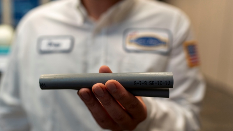 Tech displaying a polybutylen pipe in their hand