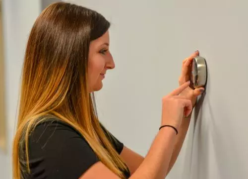 woman setting thermostat