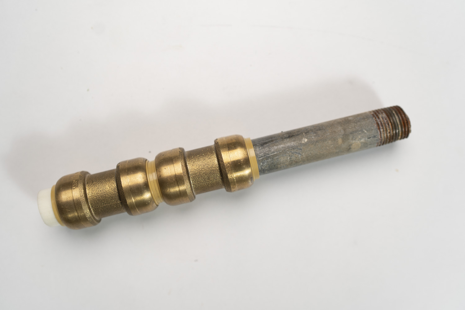 A metal valve stem with multiple brass rings and a threaded end, set against a plain white background.