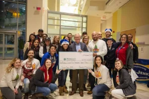 A group of people posing for a picture with a check.
