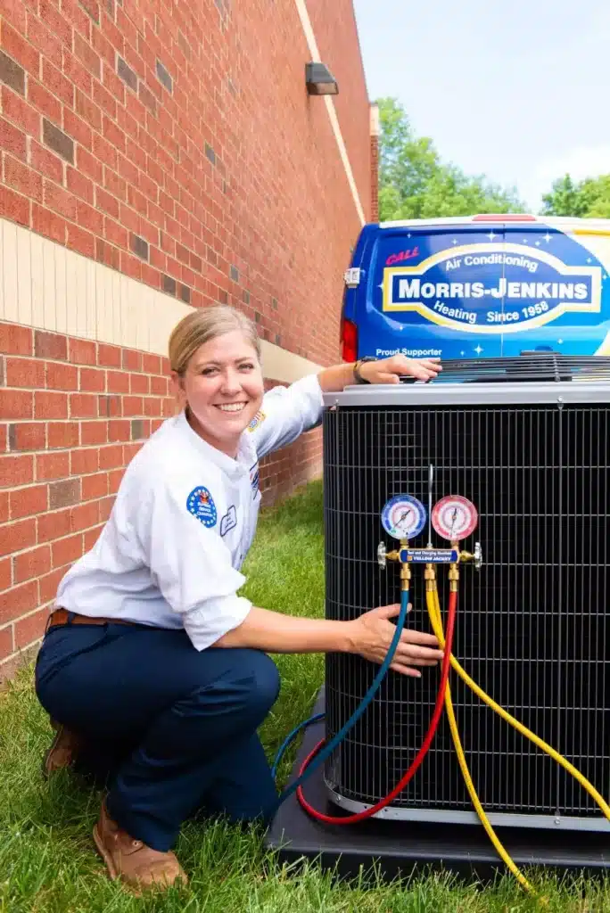 Morris-Jenkins service technician next to an air conditioning unit