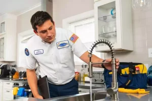 A plumber working on a kitchen sink.