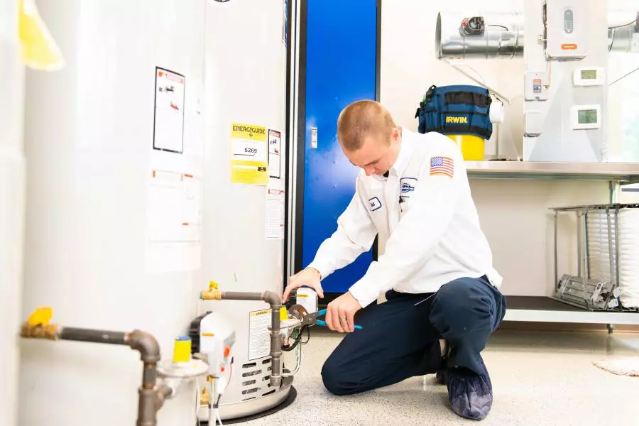 Morris Jenkins Plumber working on a tank water heater.