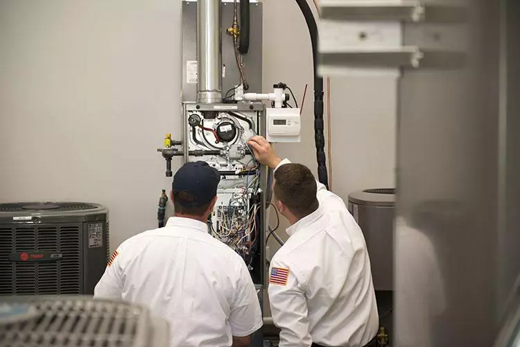 morris jenkins trainee and teacher working on a furnace