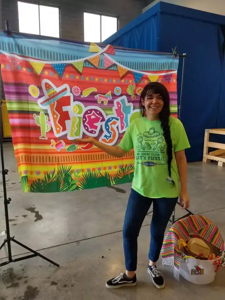 Taya posing in front a fiesta banner.