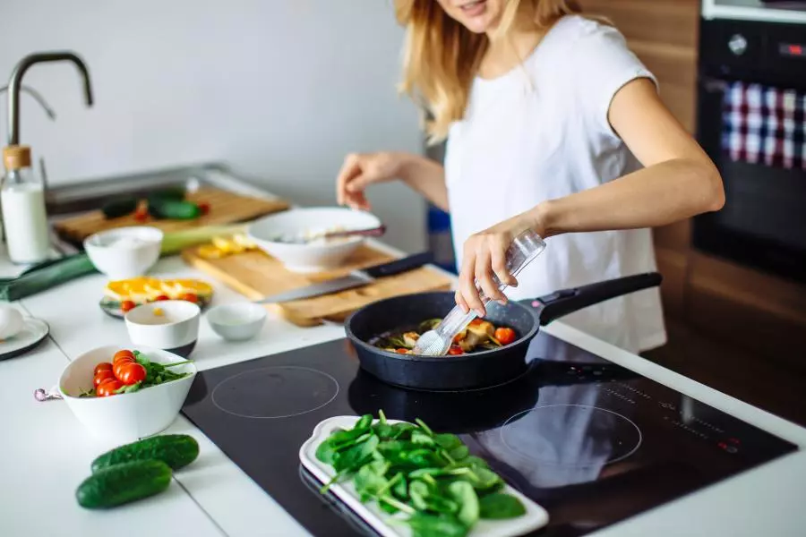 A woman is preparing food in a kitchen.