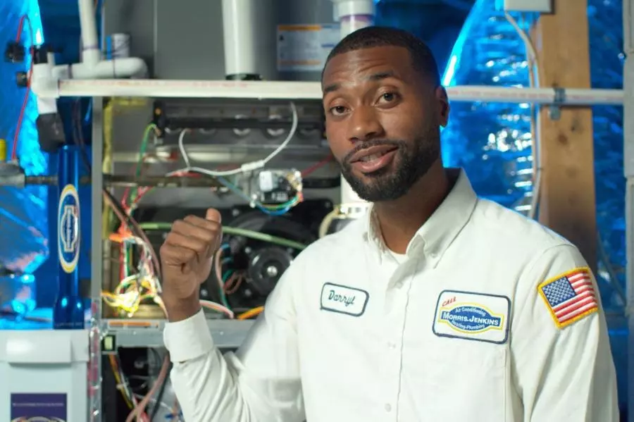 Morris-Jenkins service tech standing in front of an AC unit