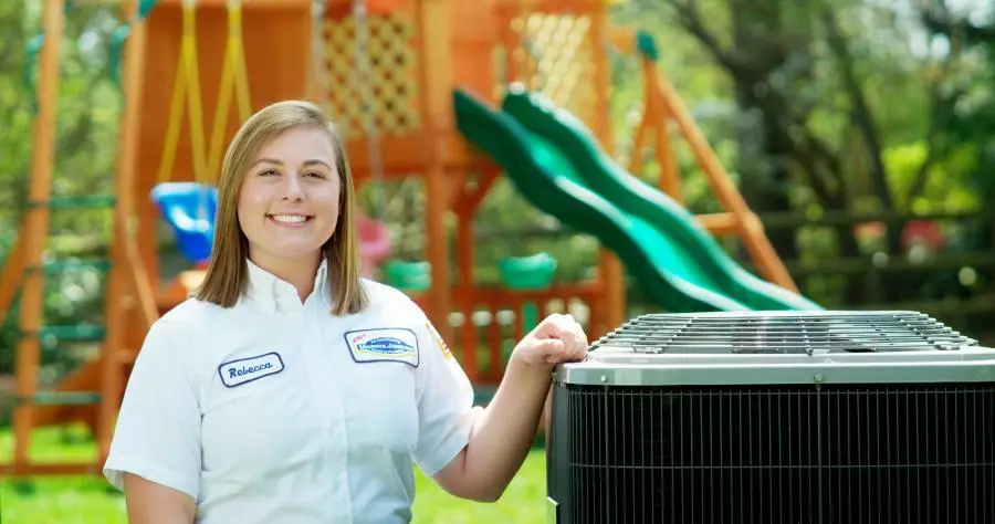 Morris-Jenkins tech standing in front of an air conditioner.