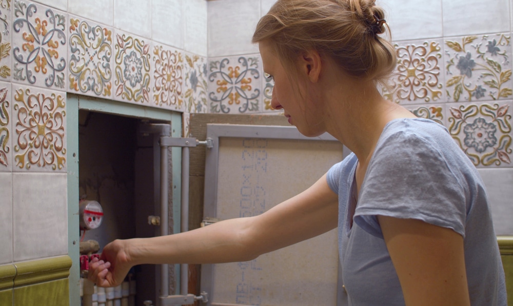 Woman turning off main water shut-off valve