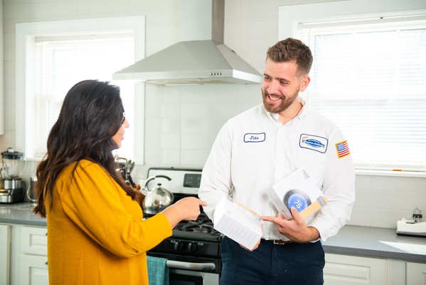 Technician showing Nest Protect CO Detector to customer