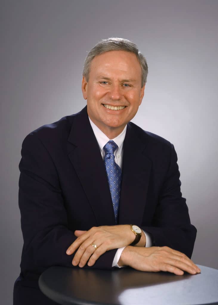 A man in a suit and tie sitting at a table.