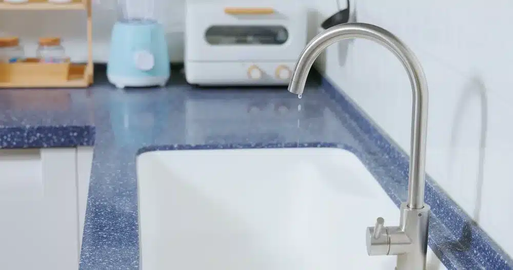 A kitchen sink with a blue counter top.