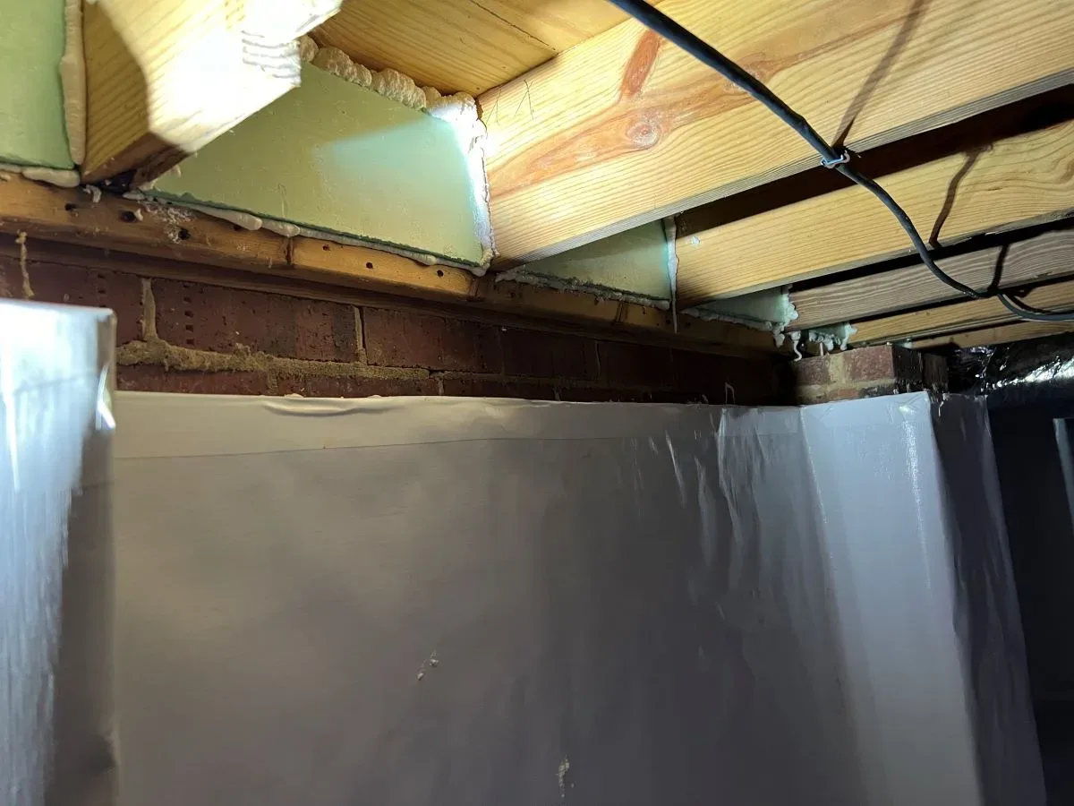 A basement with a tarp covering the ceiling.